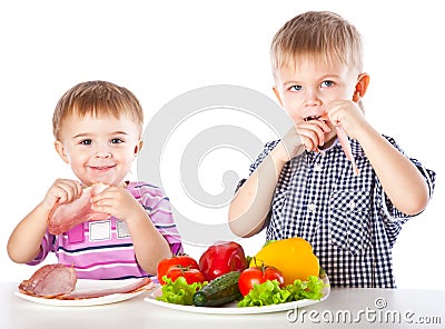 Boys and plates of vegetables and meat Stock Photo