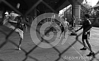 Boys play sepak takraw on streets of Bangkok Editorial Stock Photo