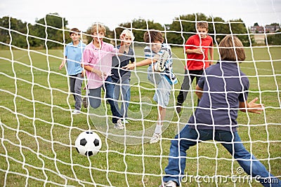 Boys playing soccer in park Stock Photo