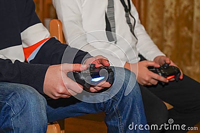 Boys are playing Sony PlayStation. Boy playing with a joystick. A boy enjoy playing game on Sony PlayStation at home. Hand boy Stock Photo