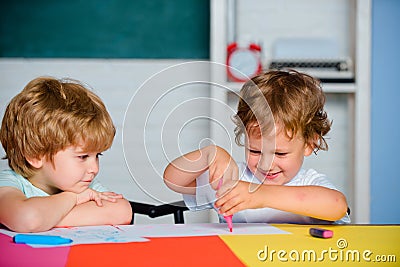 Boys Pupils from elementary school drawing at the school. Cheerful smiling little pupils having fun. Happy cute clever Stock Photo