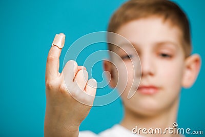 Boys thumb with white medical adhesive plaster Stock Photo