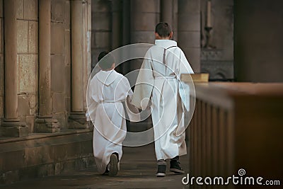 Boys with white tunic dress during communion in the church Stock Photo