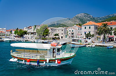 Brac, Croatia - May 17, 2016: Colourful Taxi boat in water of Marina Bol port of Pain in front of olt town Editorial Stock Photo