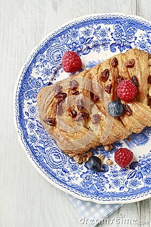 Braided danish bun made of puff pastry decorated with fresh fruits Stock Photo