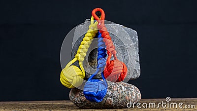 Braided paracord keychain on a background of stones. Stock Photo