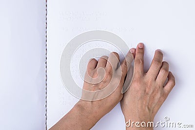 Braille book with visual impaired, low vision, blind person`s hand/ finger touching paper texture reading the sign Editorial Stock Photo