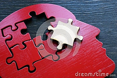 Brain problems or mental illness. The shape of a human head with a puzzle piece. Stock Photo