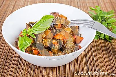Braised chopped eggplants with other vegetables in bowl close-up Stock Photo