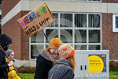 Women hold up a sign with text 