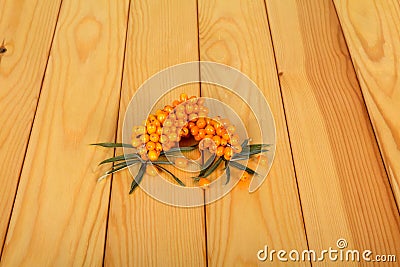 Branches with ripe sea-buckthorn berries on light wood background. Stock Photo