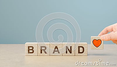 brand loyalty. Increasing customer loyalty. Build brand loyalty concept. Wooden cube blocks with BRAND text and red heart icon. Stock Photo
