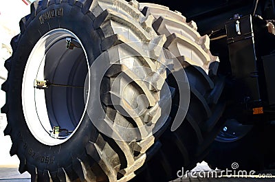 Brand new big tires placed with a large protector, mounted on a agricultural combine tractor Stock Photo