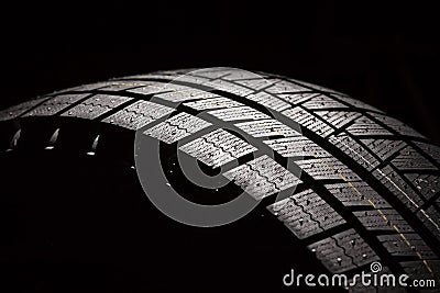 Brand new car tyre on a black background. Stock Photo