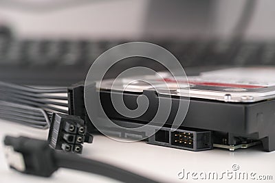 A brand new high capacity hard disk drive with SATA and power cables nearby Stock Photo