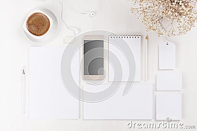 Branding business mock up of white blank stationery set, phone, flowers, coffee cup on light soft white wooden background. Stock Photo