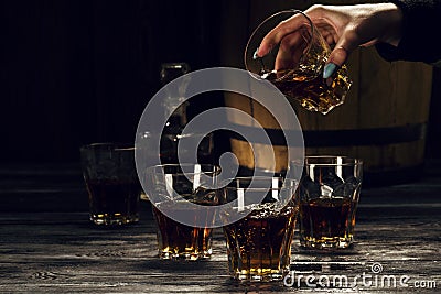 Brandy in decanters stand on an oak barrel Stock Photo