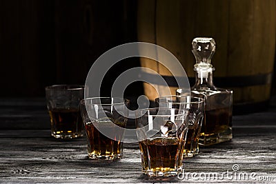 brandy in decanters stand on an oak barrel Stock Photo