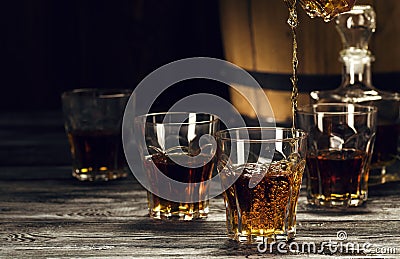 brandy in decanters stand on an oak barrel Stock Photo