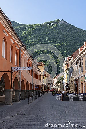 City name Brasov written with huge white letters on Mount Tampa is seen from the narrow streets of the old town Editorial Stock Photo