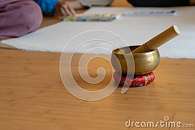 Brass bowl on the cloth base lay on the wood floor. It`s the Asian vintage gimmick to ring a signal and sound for notice the Stock Photo