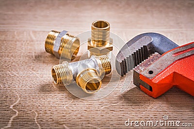Brass Pipe Connectors And Monkey Wrench On Wooden Stock Photo