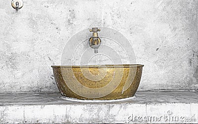 Brass sink and faucet on cement wall Stock Photo