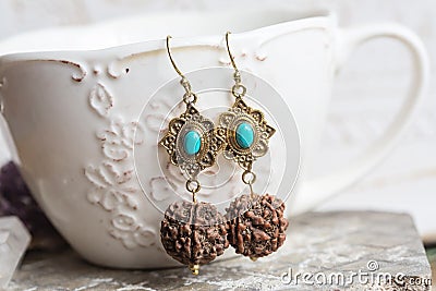 Turquoise stone Indian seed earrings on white cup background Stock Photo