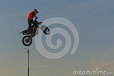 A brave biker jumps very high on a motorcycle and performs a stunt. Editorial Stock Photo