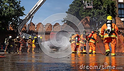 Brave firefighter using extinguisher and water from hose for fire fighting, Firefighter spraying high pressure water to fire, Editorial Stock Photo