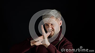 Brave handsome man standing in defensive karate posture punching to camera, threatening to attack Stock Photo