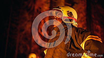 Brave Handsome Young African American Firefighter in Safety Uniform and a Helmet Looking Around the Stock Photo