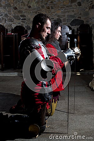 Brave Knights Praying in the Old Church Before the Battle Stock Photo