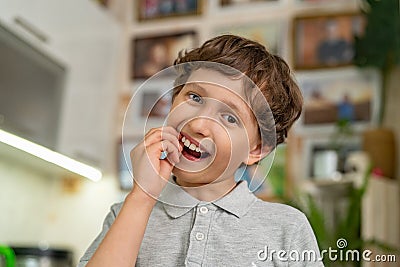 A brave little boy of 7 years old shakes his baby tooth Stock Photo