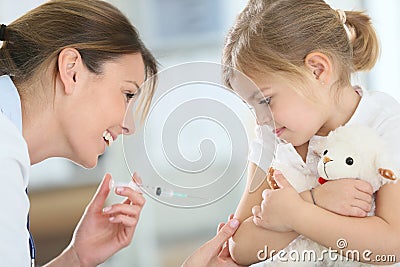 Brave little girl receiving injection by doctor Stock Photo