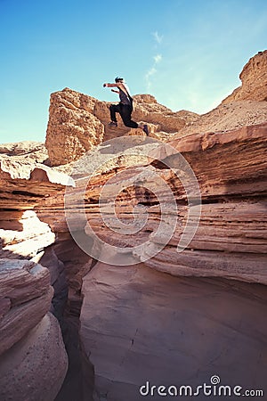 Brave man jumping over the cliff in canyon Stock Photo