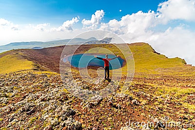 Man on a summit of Azhdahak volcano watching crater lake, Geghama mountains, Armenia Editorial Stock Photo