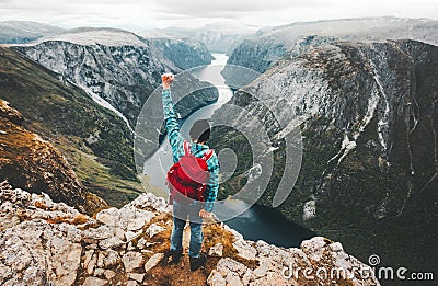 Brave Man traveling in Norway mountains standing on cliff Stock Photo