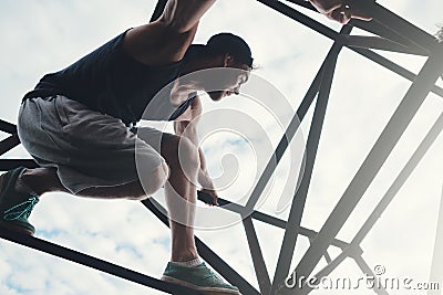 Brave and risky man sitting on the top of high metal construction Stock Photo