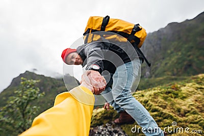 Brave traveler hold hand his friend for helping climb to mountain lifestyle outdoor journey Stock Photo