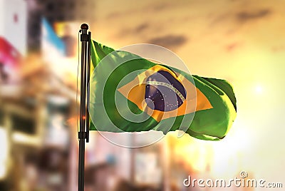 Brazil Flag Against City Blurred Background At Sunrise Backlight Stock Photo