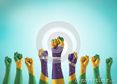 Brazil flag on people hands with clenched fists raising up for labor day, republic proclamation day, national holiday celebration Stock Photo