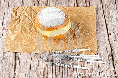 Brazilian cream donuts on brown paper, next to several syringes and ampoules of insulin Stock Photo