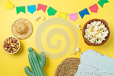 Brazilian Festa Junina party background with popcorn, peanuts, cactus and colorful banners. Top view from above Stock Photo