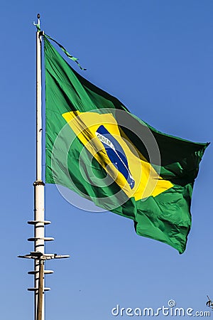 Brazilian flag flutters on a flagpole with the blue sky Stock Photo