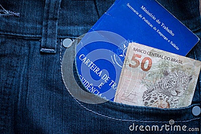 Brazilian labor portfolio and fifty reais bills in jeans pocket Stock Photo