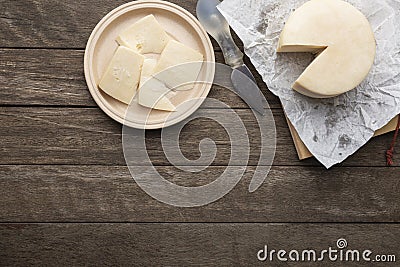 Brazilian Mantiqueira artisanal cheese with slices over a wooden table. Top view with copy space Stock Photo