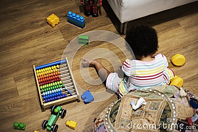 Brazilian toddler girl playing wooden toys on the floor Stock Photo