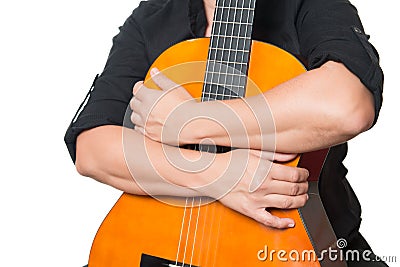 Brazos que abrazan una guitarra acústica