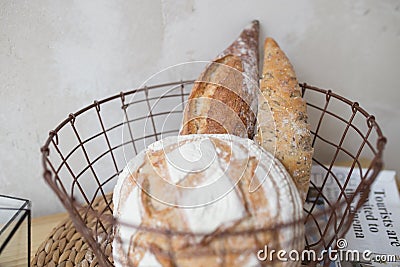Bread in the basket. loaf and baguette in the kitchen, homemade pastries with powder. delicious flour products Stock Photo